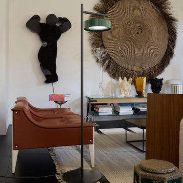 Oluce Berlin-Out floor lamp beside an armchair and desk in a living room