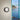 Oluce Berlin-Out black round wall lamp on a pale wall beside a window with a sea view