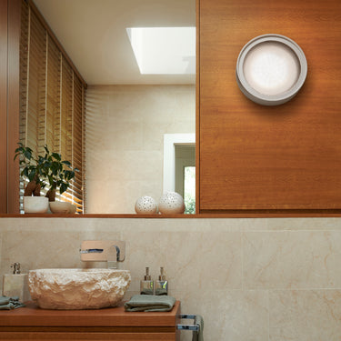 Oluce Berlin-Out round wall lamp above a bathroom vanity and mirror