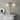 Array twin table lamp with two lit opal glass globes beside a fireplace