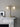 Array twin table lamp with two lit opal glass globes beside a fireplace