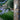 Oluce Berlin-Out round wall lamp on a stone wall beside a flowering garden
