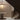 Nimbus chandelier lit above a round marble table at the foot of a curved staircase