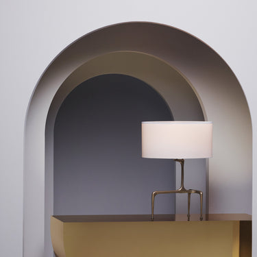 Braque table lamp on a gold plinth framed by a curved archway
