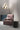 Group of three Abstract wall lights above a pink velvet armchair and a round black pouf