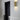 Ring wall light in brass on a white wall beside a dark door