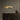 Avalon chandelier in satin brass above a dark wood bar counter between pale columns