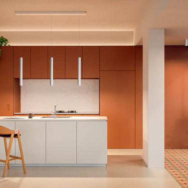 Slim tubular LED flush mount ceiling light A-Tube by Lodes in matte white finish over kitchen island