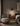 ET2 Abyss black mini cone pendant hanging beside a bed with an upholstered chair and nightstand