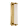 Polished natural brass Alo Small Sconce by Visual Comfort with fluted glass shade, mounted vertically in a modern bathroom.