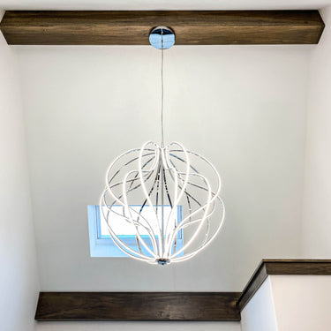 Polished Chrome ET2 Aura pendant hanging in a bright entry with a high ceiling and dark wood shelf
