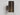 Close-up of the brushed bronze body of the Torres wall light above its honed alabaster shade