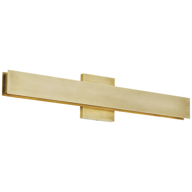 Bau 24 inch wall light, Natural Brass, installed above a bathroom vanity mirror.