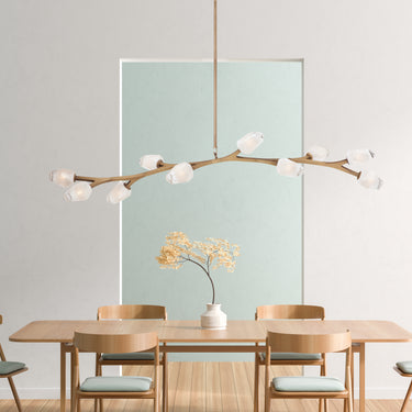 ET2 Blossom long branch pendant over a wood dining table with a pale blue artwork behind