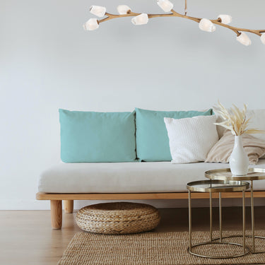 ET2 Blossom long branch pendant above a daybed sofa with teal cushions