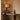 Roc table lamp glowing in a corner on a timber desk beside framed abstract art and a bentwood chair