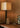 Close view of the Roc linen shade, bronze column and travertine base on a timber desk