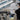CTO Lighting team member holding an opal glass globe beside a rack of fixture arms