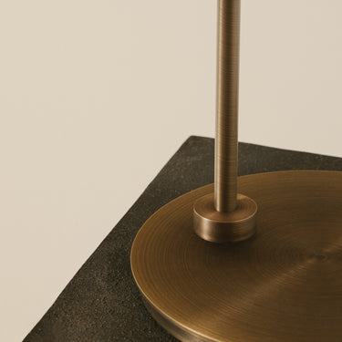 Close-up of the bronze round base and stem of the Heron table lamp