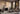 Three Hepworth wall lights on a paneled wall above a fireplace in a living room