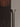 Close-up of the polished nickel Torres floor lamp funnel in front of a dark slatted panel