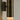 Close-up of the Roma wall light with a brushed bronze body and a glowing alabaster base