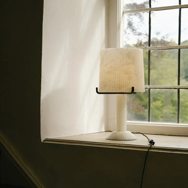 Acropolis table lamp on a window ledge with green garden view