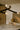 Crossing bronze strands with glass tips of the Trace Linear chandelier above a marble countertop
