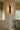 Contour wall light with textured glass beside a window above a bathtub