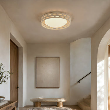 ET2 Cambria plaster flush mount on the ceiling of a stone-walled entry hall with an arched doorway, staircase and wood bench
