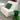 White Check chair with a green pillow beside a green stool
