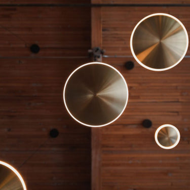 Modern entryway featuring Graypants Chrona vertical brass pendant as accent lighting.