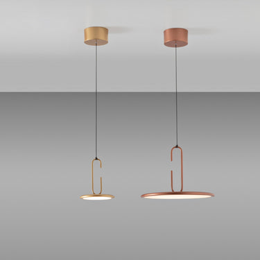 Penta Clip pendants in matt gold and matt bronze hanging from the ceiling against a gray backdrop
