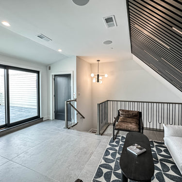 ET2 Cog globe chandelier seen from a loft landing with black and white patterned rug and slatted ceiling