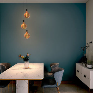 modern adjustable pendant light with black cord for kitchen or commercial use, installed in a dining room