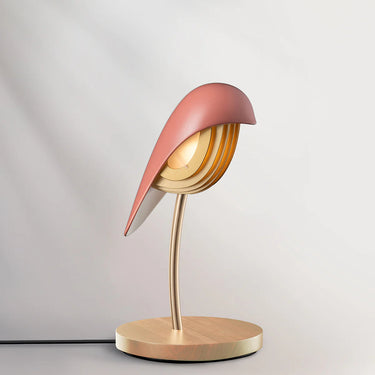 Daqiconcept Bird LED Dimmable Table Lamp - Burnt Brick BR01BBL illuminating a book on a bedside table