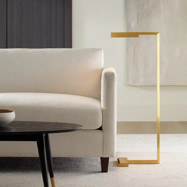 Dessau floor lamp, illuminated arm rotated, showcasing directional task light, brass finish