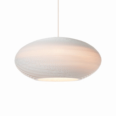 Warm ambient lighting fixture Graypants Disc in a dining room setting.