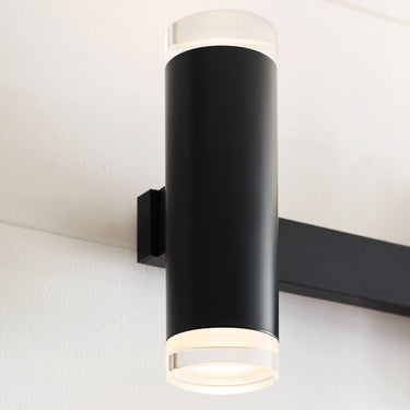 View of matte black integrated LED bathroom light, cylindrical glass shades