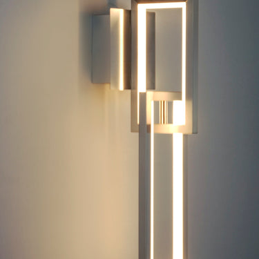 ET2 Link chain link wall sconce, Satin Nickel, lit against a dark wall