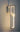 ET2 Link chain link wall sconce, Satin Nickel, lit against a dark wall