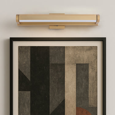ET2 Braque faceted aluminum picture light in Gold mounted above a framed abstract artwork on a gray wall