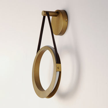 ET2 Tether suspended ring wall sconce, Natural Aged Brass, side view of the ring hanging from a brown strap