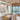 ET2 Soji lantern glass wall sconce on the kitchen wall beside a dining room with a wood-plank ceiling