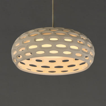 ET2 Cambria Small plaster pendant lit, warm glow through the oval cutouts of the dome shade