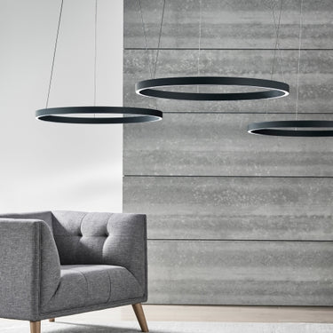 Modern 48-inch LED ring chandelier in matte black by Visual Comfort, suspended from ceiling in living room