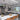 ET2 Fizz III bubble glass mini pendants over a white island with orange stools in a dark slate kitchen