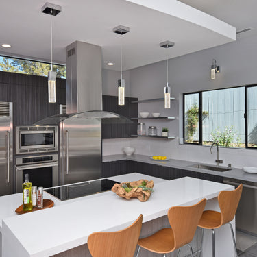 ET2 Fizz III bubble glass mini pendants over a white island with orange stools in a dark slate kitchen