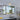ET2 Fizz III bubble glass wall sconce above a kitchen sink window with a vent grille overhead