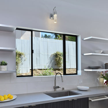 ET2 Fizz III bubble glass wall sconce above a kitchen sink window with a vent grille overhead